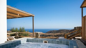 Un jacuzzi con vistas claras al mar y una pared de piedra.