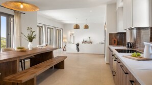 Una cocina moderna con una mesa de comedor de madera, un banco y luces colgantes.