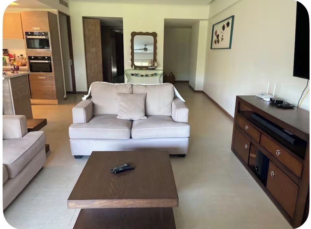 A living room with a sofa, a coffee table, and a TV stand.
