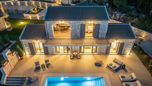 A two-story stone house with a swimming pool, outdoor seating, and a well-lit patio area. - Villa Philaea, Divine Sea Views, Private Pool, Furnished Terrace, Kefalonia (Kefalonia)