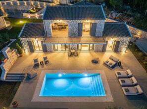 A two-story stone house with a swimming pool, outdoor seating, and a well-lit patio area. - Villa Philaea, Divine Sea Views, Private Pool, Furnished Terrace, Kefalonia (Kefalonia)