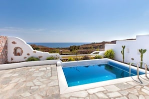 A pool with a clear view of the sea, surrounded by white walls and stone flooring. - Villa Altairia, Divine Sea Views, Private Pool, Furnished Terrace, Santorini (Santorini)