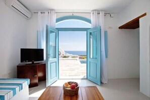 A room with an open door leading to a balcony with a view of the sea. - Villa Altairia, Divine Sea Views, Private Pool, Furnished Terrace, Santorini (Santorini)