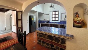 Una cocina con encimera de piedra, azulejos azules y una figura decorativa.