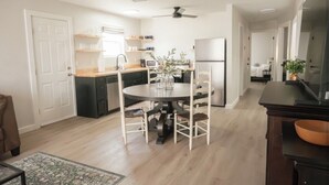 Una cucina moderna con tavolo, sedie e frigorifero.