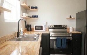 A modern kitchen with a sink, microwave, stove, and oven.