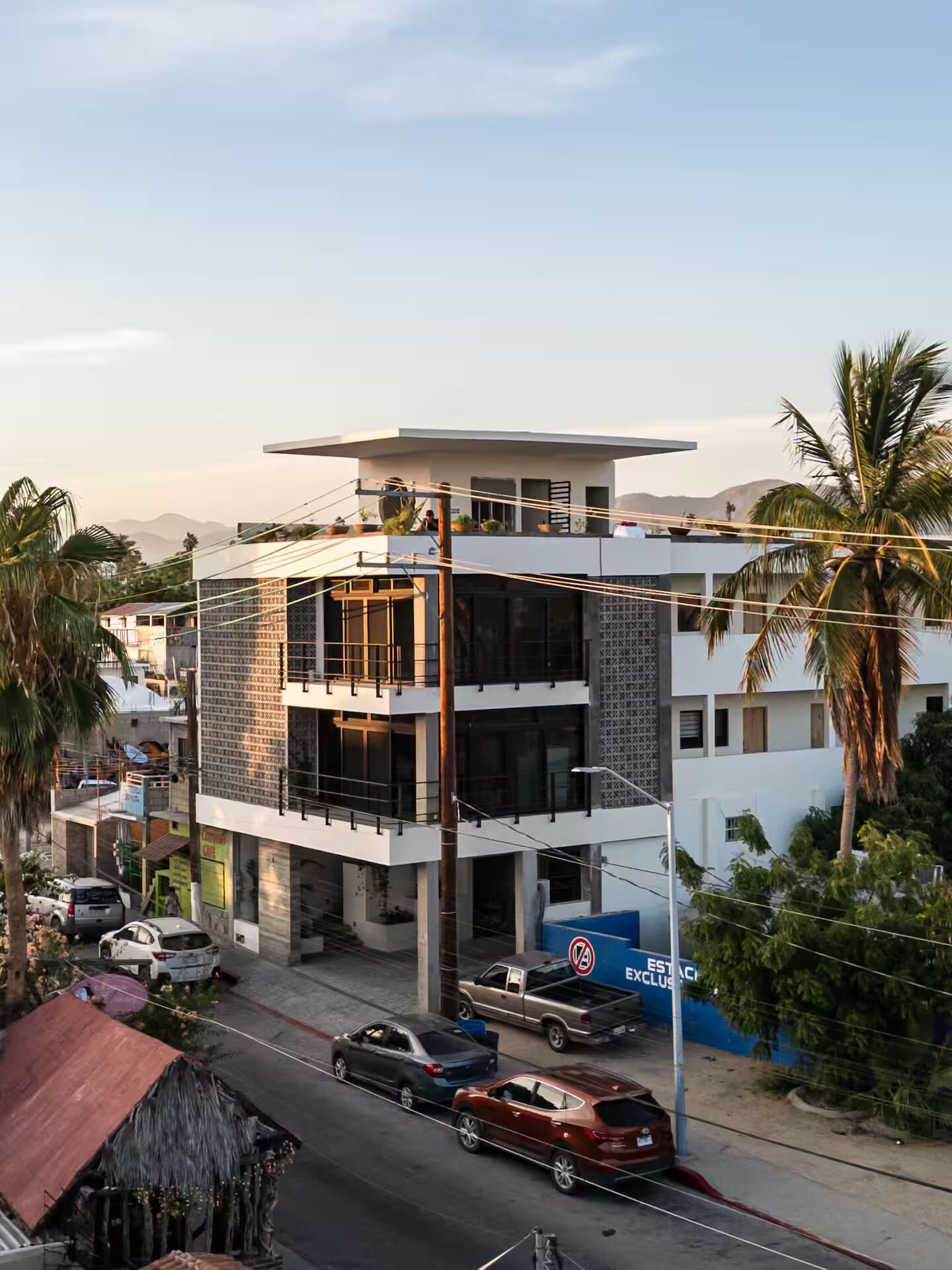 Un immeuble à plusieurs étages doté d’une architecture moderne, caractérisé par un toit plat et de grandes fenêtres.