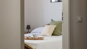 A bedroom with a bed, pillows, a bedside table with a lamp, and a tray with cups and a teapot. - Casa Marianna by Theater Home - located in the heart of Tignale with a marvellous lake view (Tignale)