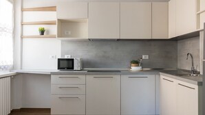 A modern kitchen with grey cabinets, a microwave, a sink, and a window with a view. - Casa Marianna by Theater Home - located in the heart of Tignale with a marvellous lake view (Tignale)