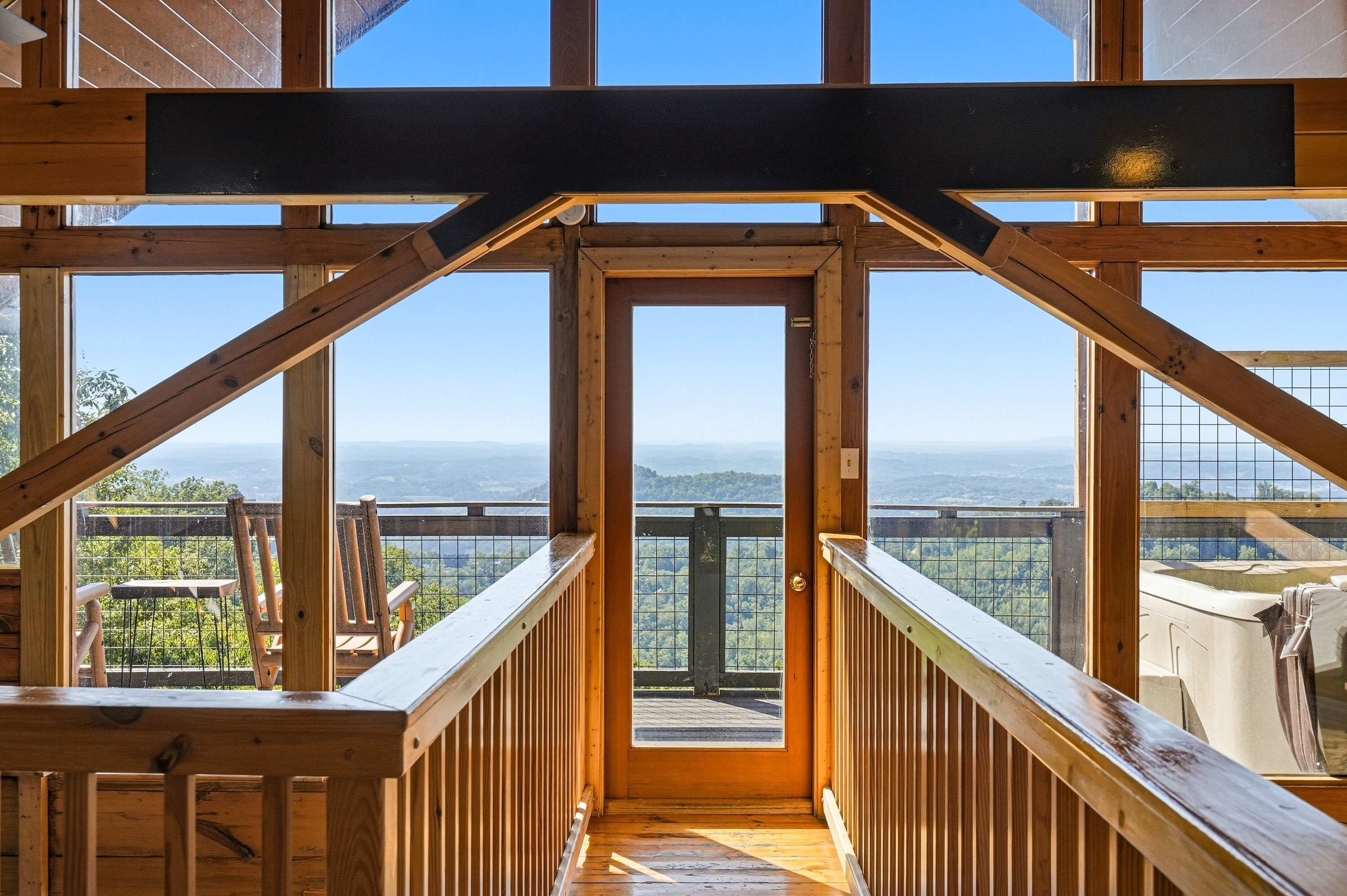 A wooden interior with a view of a mountainous landscape through large windows.