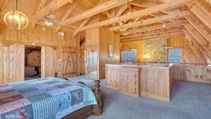A wooden cabin with a bedroom, a bathroom, and a kitchen area. - Secluded 7BR Mountain Escape on 7 Acres (Sevierville)