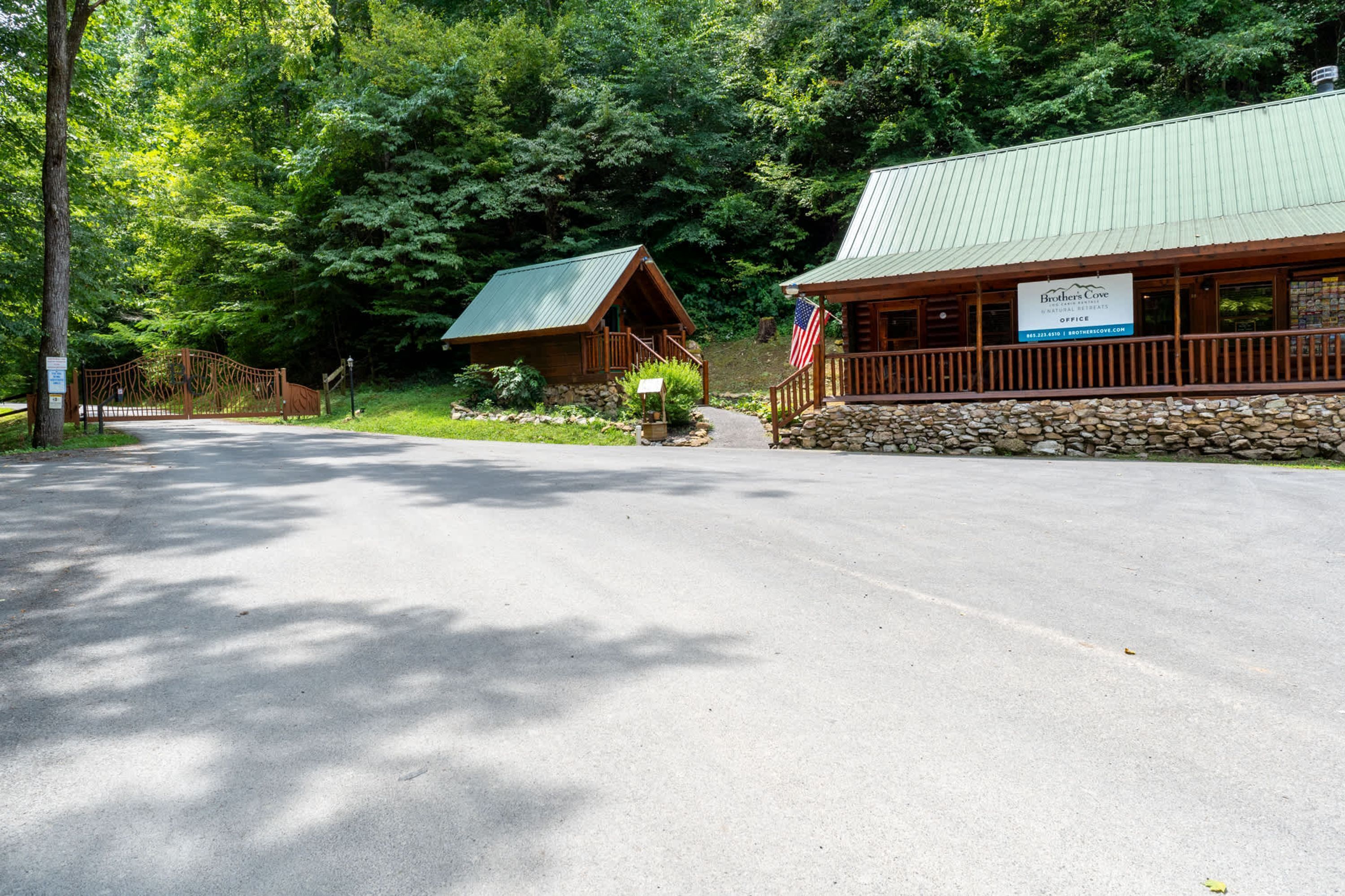 Eine Lodge mit Steinfundament und einem grünen Dach, umgeben von dichtem Wald.