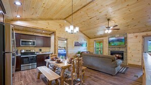 A wooden cabin interior with a kitchen, dining area, and living room. - Stunning 4 King Suites Hot Tub Views Gamerm (Gatlinburg)