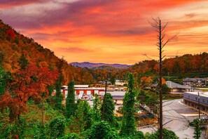 A view of a town with autumn foliage, a parking lot, and buildings in the foreground. - Stunning 4 King Suites Hot Tub Views Gamerm (Gatlinburg)