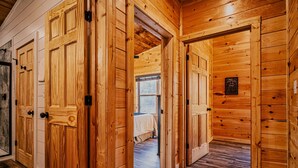 A wooden interior with multiple doors leading to different rooms. - Stylish New 5BR 4BA Cabin Steps From Dollywood (Pigeon Forge)
