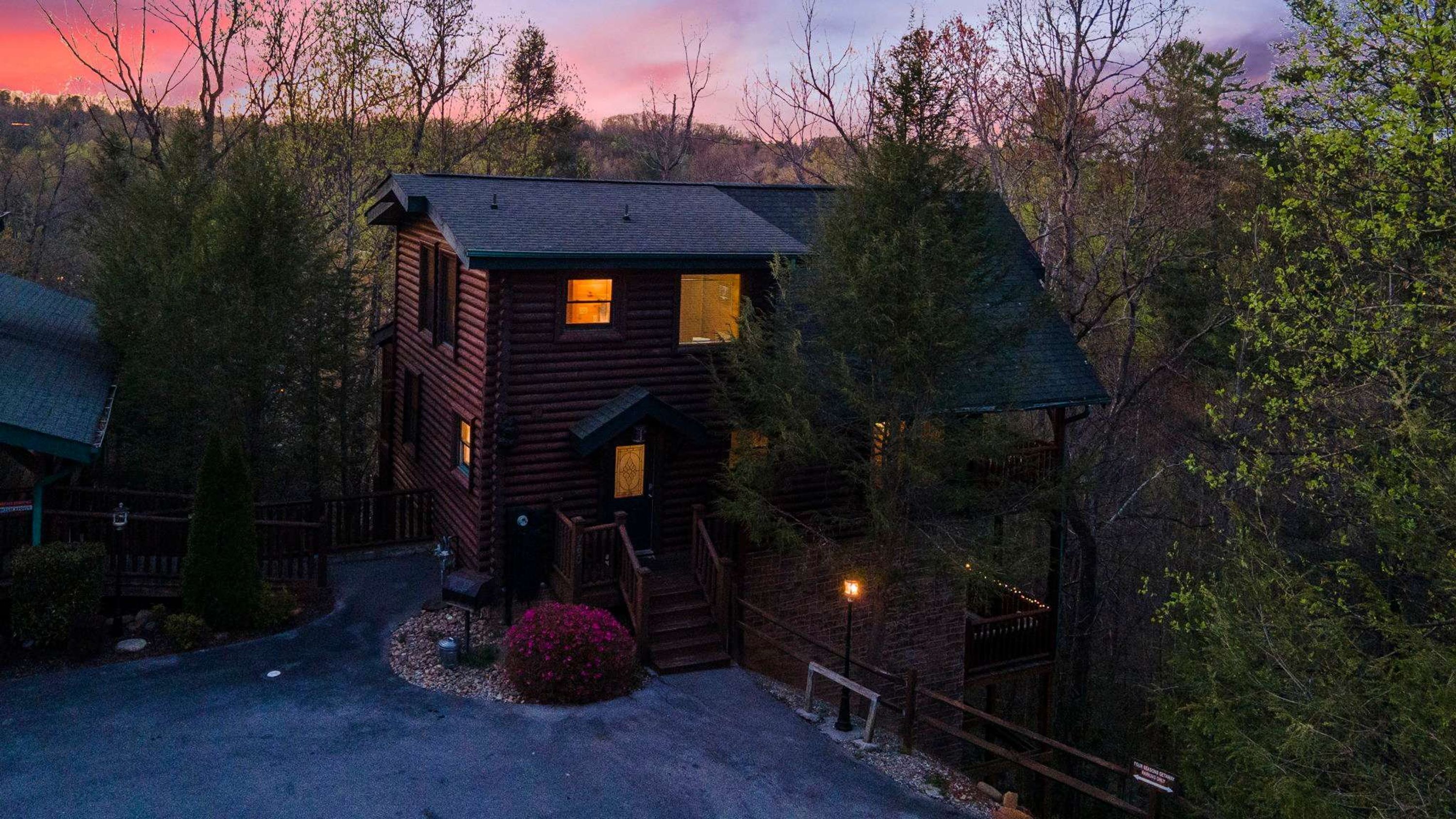 A log cabin with a porch and a small garden area.