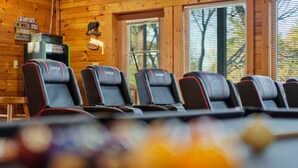 A row of black racing-style chairs with red accents in a wooden cabin setting. - Cozy Mountain Retreat With Private Hot Tub (Gatlinburg)