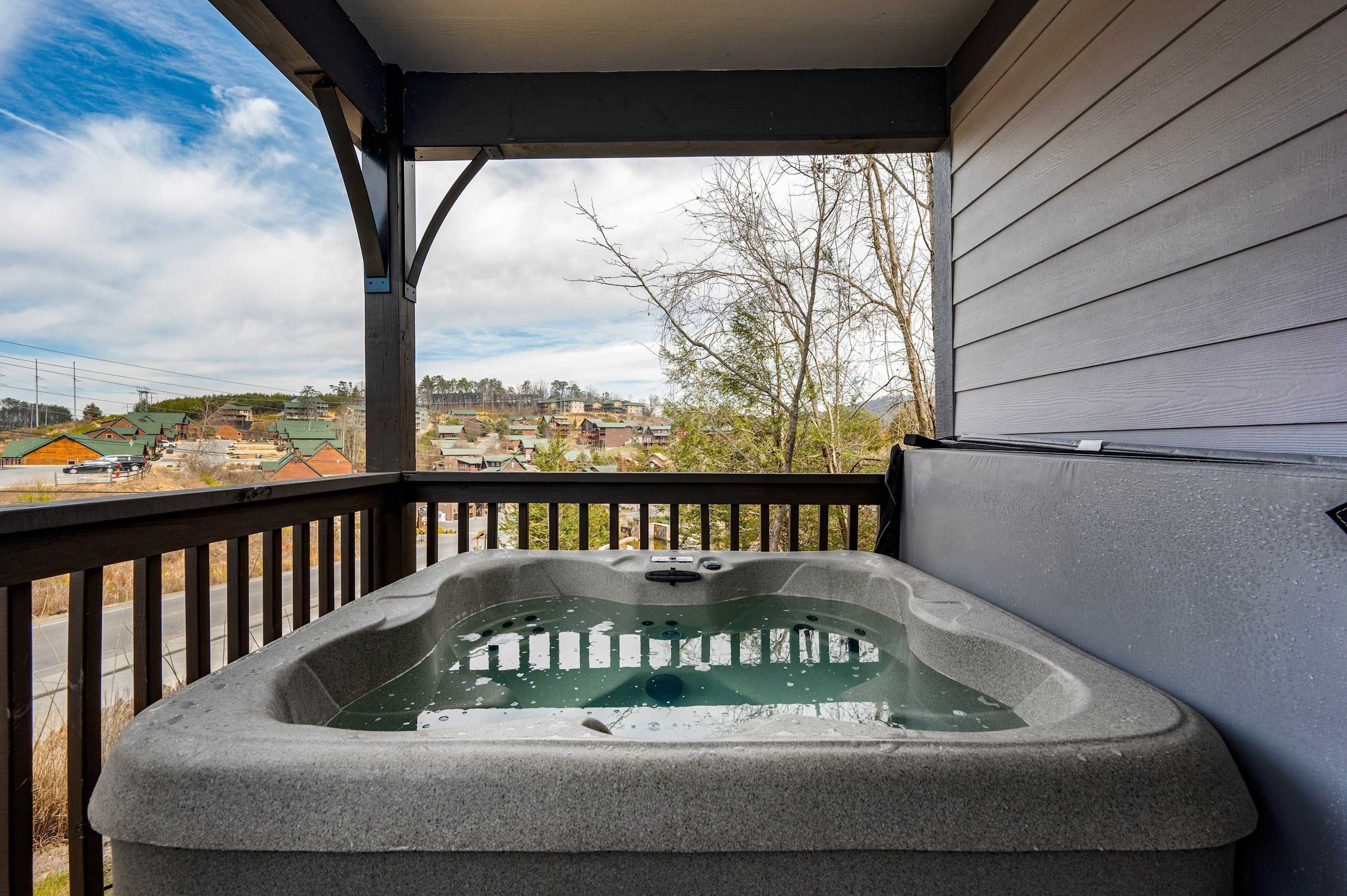 A hot tub on a balcony with a view of a residential area.