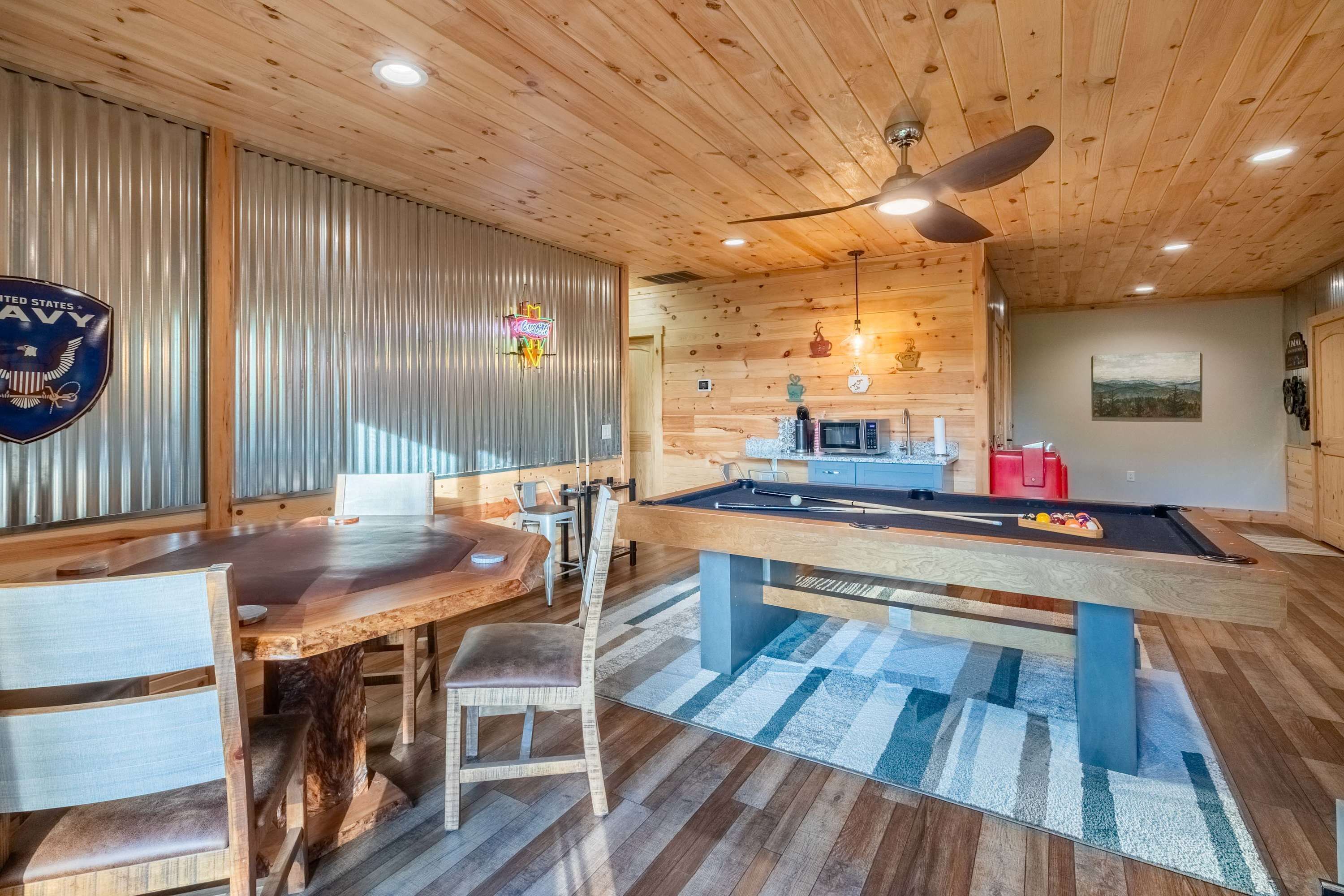 Un interior de madera con mesa de billar, comedor y sillas.