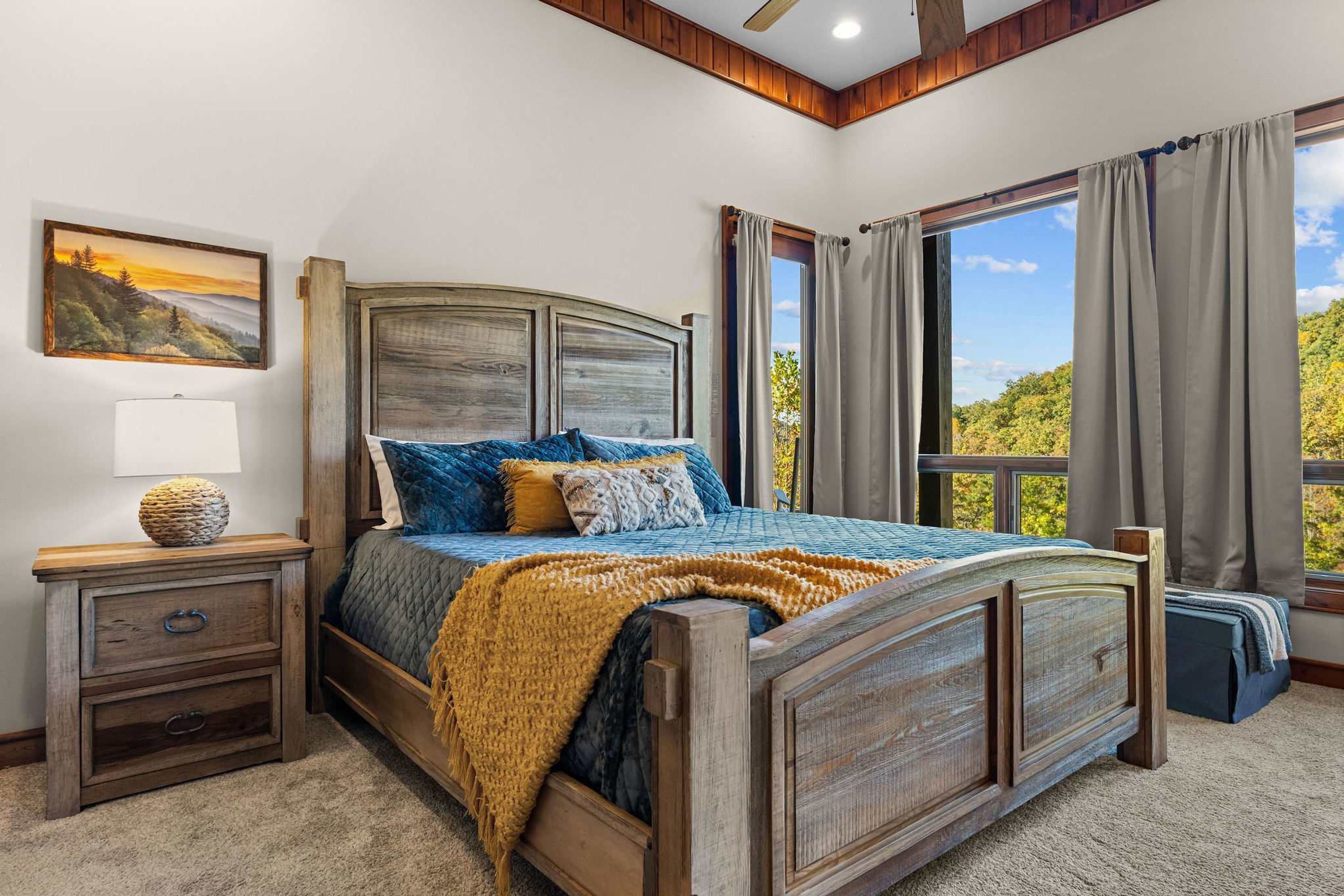A bedroom with a wooden bed, a nightstand, a lamp, and a window with curtains.