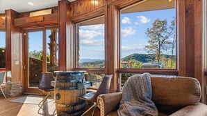 Ein gemütliches Zimmer mit Ledersofa, einem Holzbottich und einem Steinkamin.
