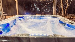 Ein Whirlpool mit Holzterrasse und Lichterkette.