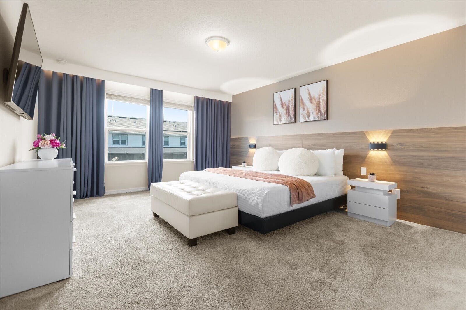 Quarto de hotel moderno com uma cama grande, uma mesa de cabeceira, um penteado e uma janela com cortinas.