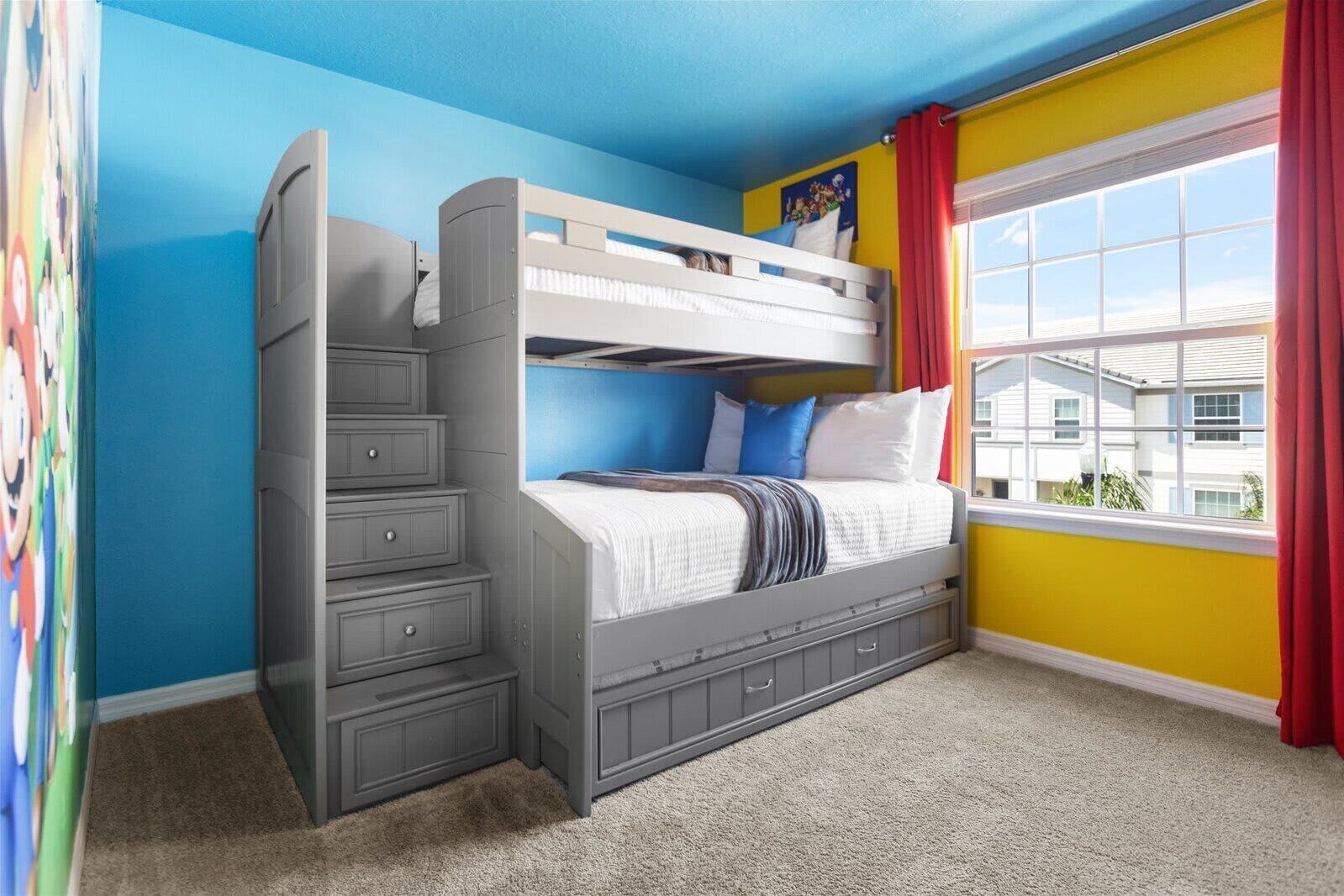 A bunk bed in a room with a blue wall, a window with a view, and a door.