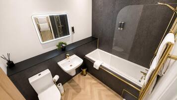 A modern bathroom with a toilet, sink, and bathtub.