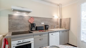 Een moderne keuken met een inbouwoven, een koffiezetapparaat, een broodrooster en een vaatwasser.