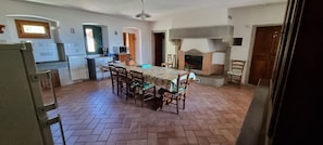 A spacious kitchen with a dining table, chairs, a fireplace, and a kitchen island. - Casa Fantone. Villa with private pool and large fenced park for absolute privacy (Poppi)