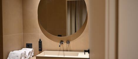 A bathroom with a large mirror, a sink, and a towel on the counter.
