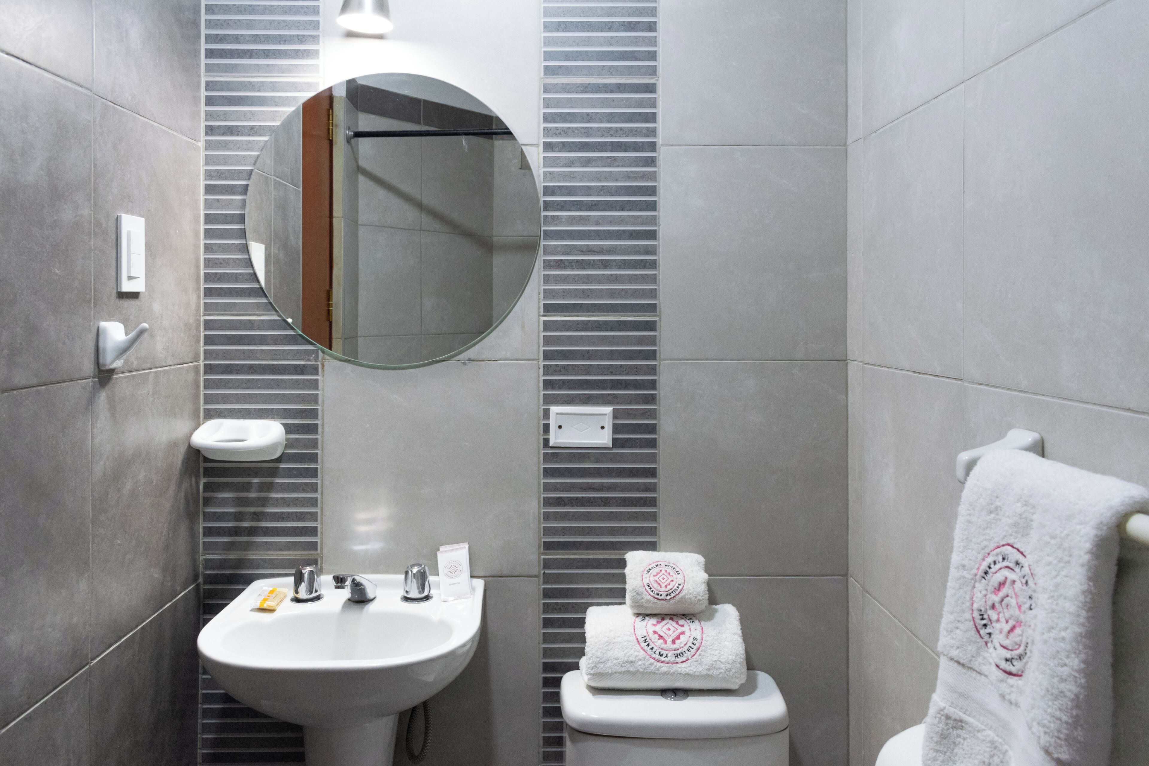 Une salle de bain moderne avec un lavabo, un miroir et des toilettes.