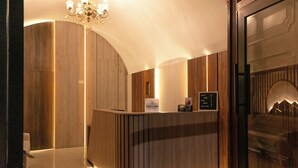 A reception area with a wooden reception desk, a chandelier, and a sign that reads 'INKALMA.' - Inkalma Santa Marta (Arequipa)