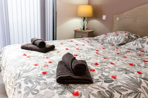 Una camera d'albergo con un letto, un comodino e una lampada.