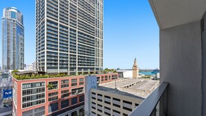 A high-rise building with a modern architectural design, featuring multiple balconies and a view of a historic tower in the background. - Chic Studio in the Heart of Miami 4 Guests (Miami)