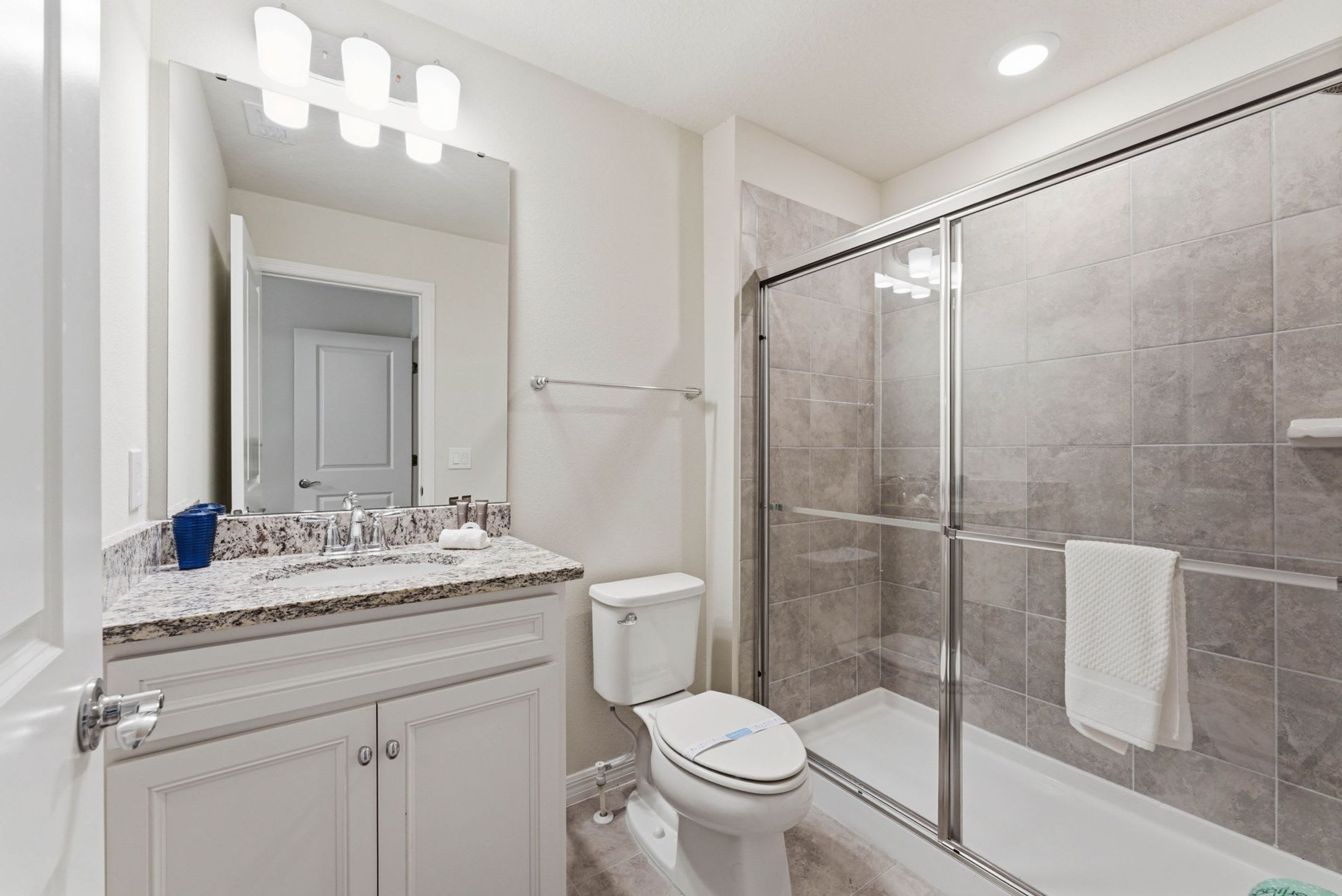 A bathroom with a shower, toilet, and vanity.