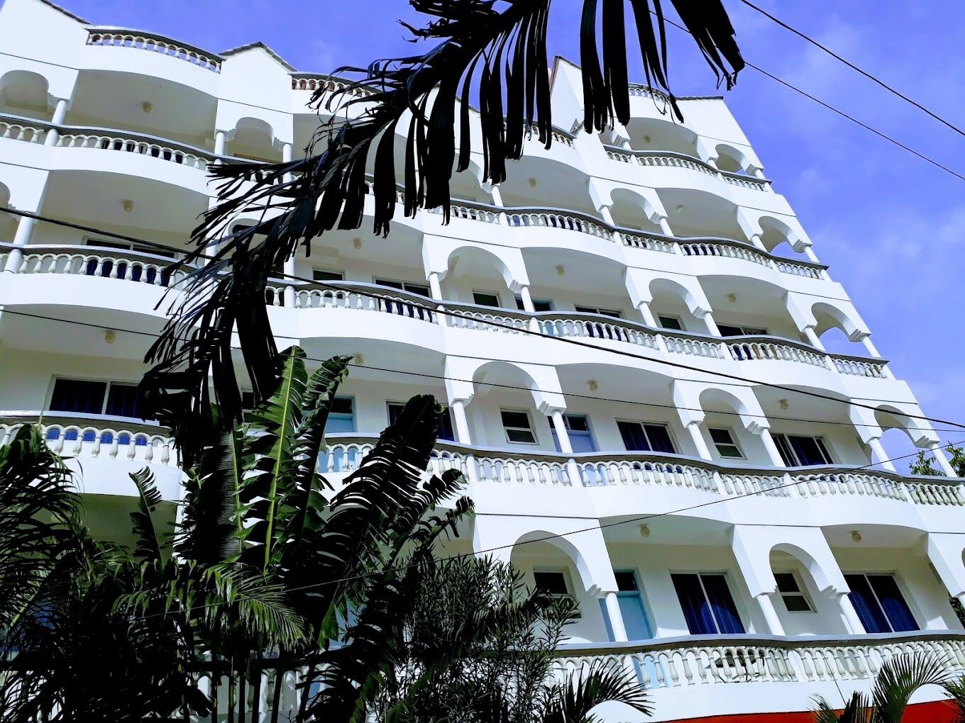 A multi-story building with balconies and arched windows.