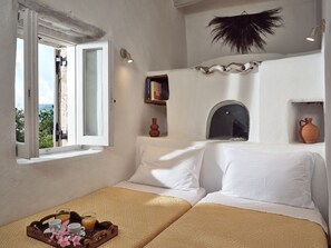 A room with a bed, a window, a shelf with books, and a decorative item on the wall. - Villa Rheline, Divine Sea Views, Private Pool, Spacious Furnished Terrace,. (Zakynthos)