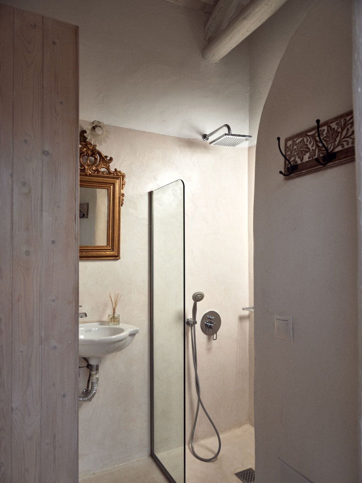Une salle de bain avec une douche, un lavabo et un miroir.