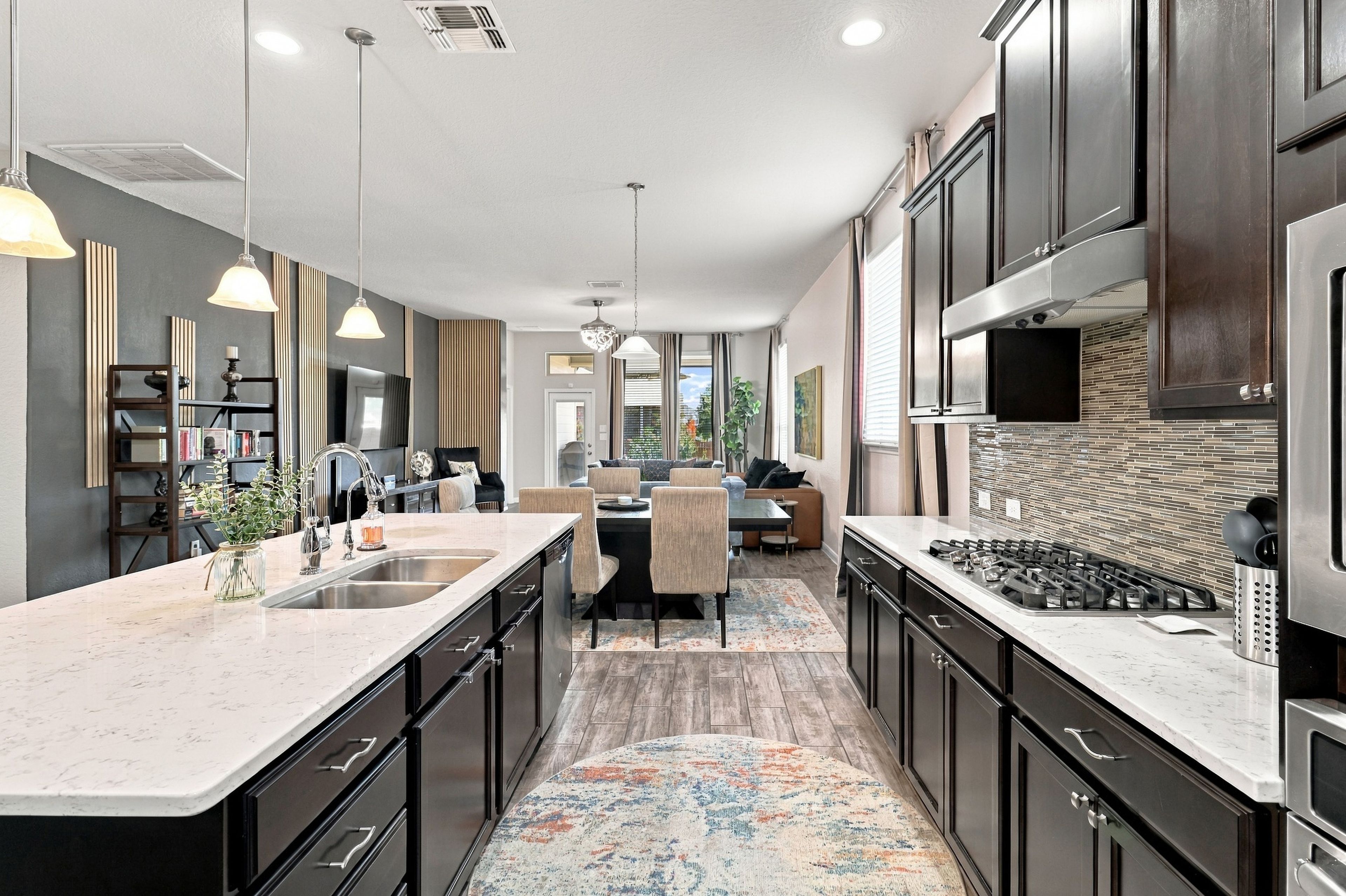 Une cuisine moderne avec des meubles de couleur sombre, un îlot central et une grande cuisinière.