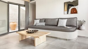 Un salon moderne avec un canapé gris, une table basse en bois et une grande fenêtre donnant sur un beau paysage.