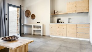 Une cuisine moderne avec des meubles en bois, un évier encastré et un coin repas équipé d’une banquette.