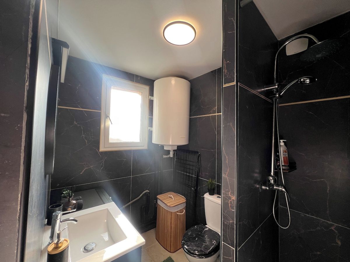Un baño moderno con ducha, inodoro y lavamanos.