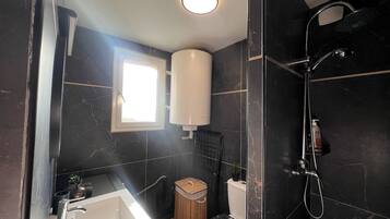 Un baño moderno con ducha, inodoro y lavamanos.