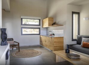 A modern kitchen with wooden cabinetry, a built-in sink, and a window overlooking a snowy landscape.