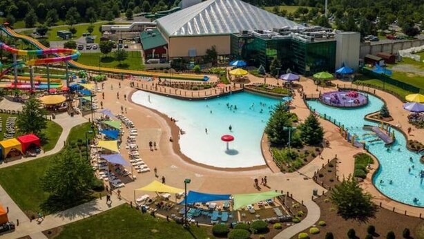 A water park with multiple pools, slides, and a large building with a sloped roof. - Cozy 1-bedroom resort with AC in welcoming Massanutten with waterPark access (Massanutten)