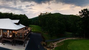 A lodge with a large deck, a covered outdoor seating area, and a view of a golf course. - Cozy 1-bedroom resort with AC in welcoming Massanutten with waterPark access (Massanutten)