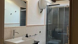 Un baño moderno con tragaluz, cabina de ducha y retrete.
