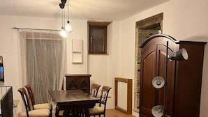 Un área de comedor con una mesa y sillas, un sofá, una lámpara de pie y un armario.